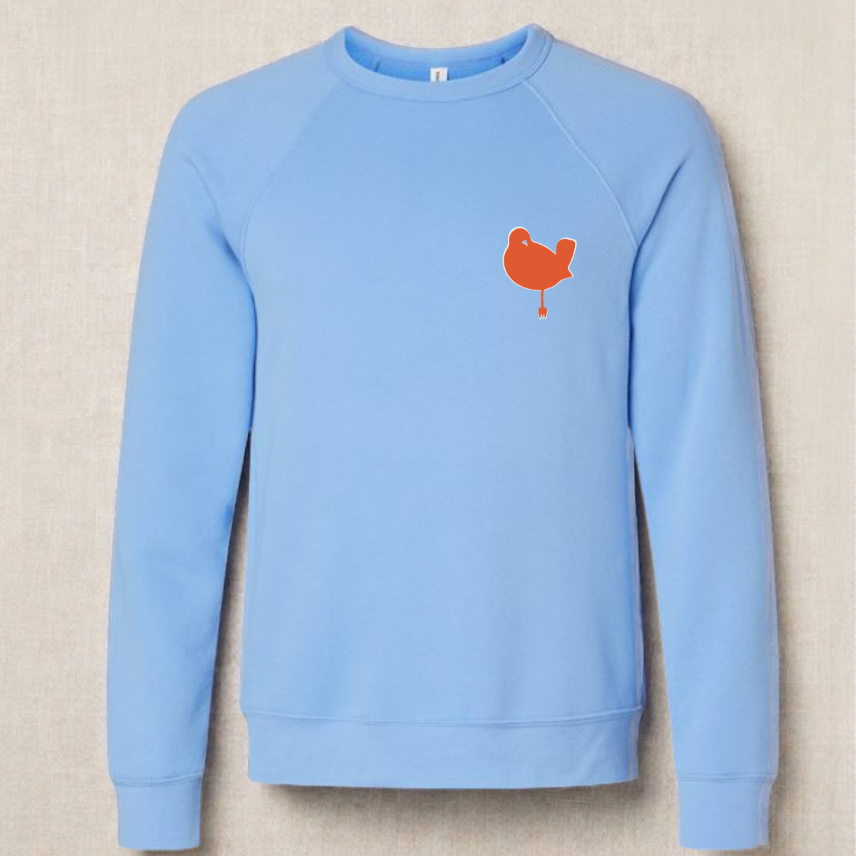 Carolina Blue Bambird Scramble crewneck laid flat, orange bird logo on the left chest